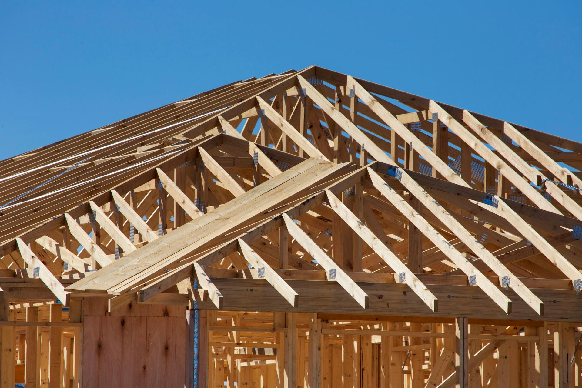 Wood-framed house under construction at sunset