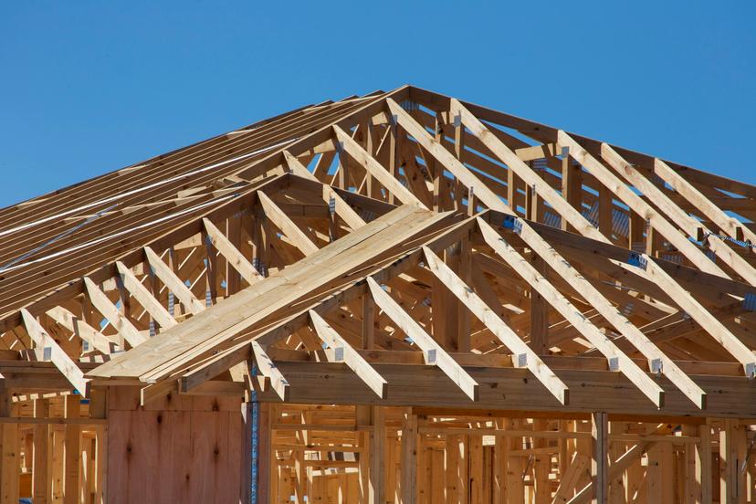 Wood-framed house under construction at sunset