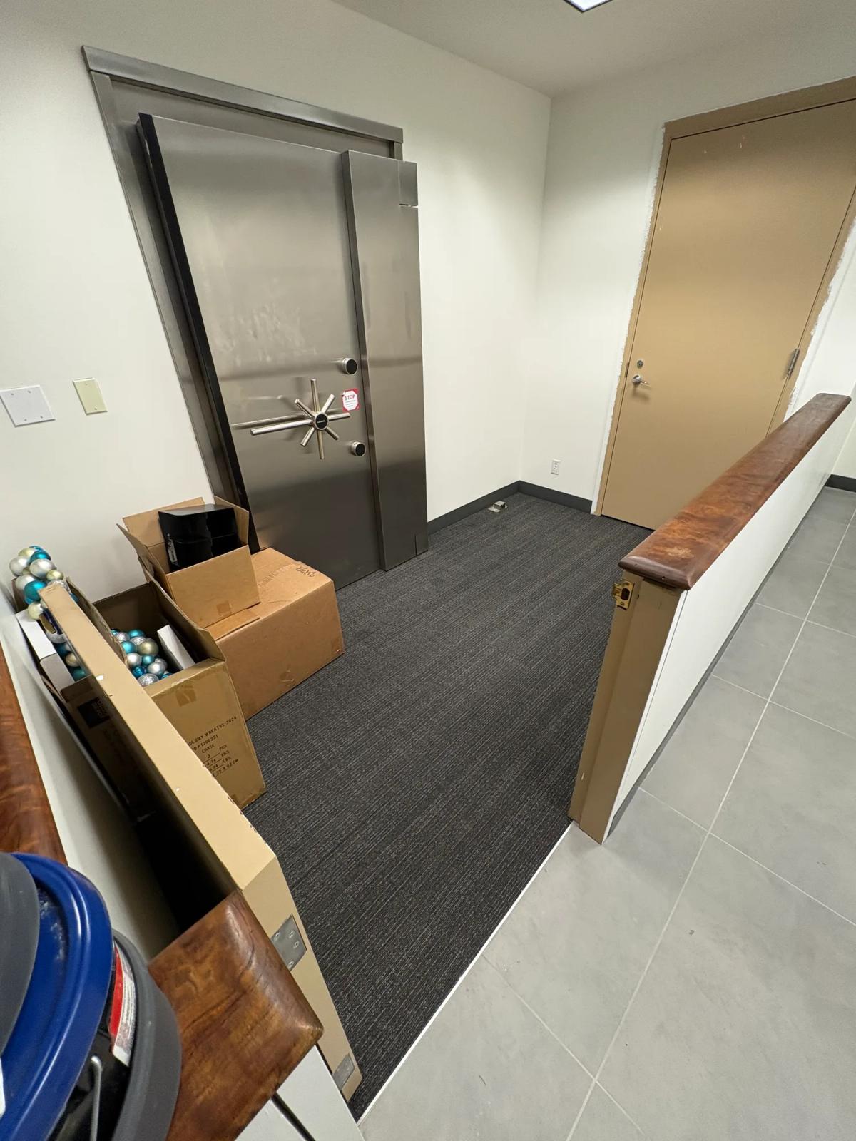 Carpet tile carried through the back-of-house corridor by the vault
