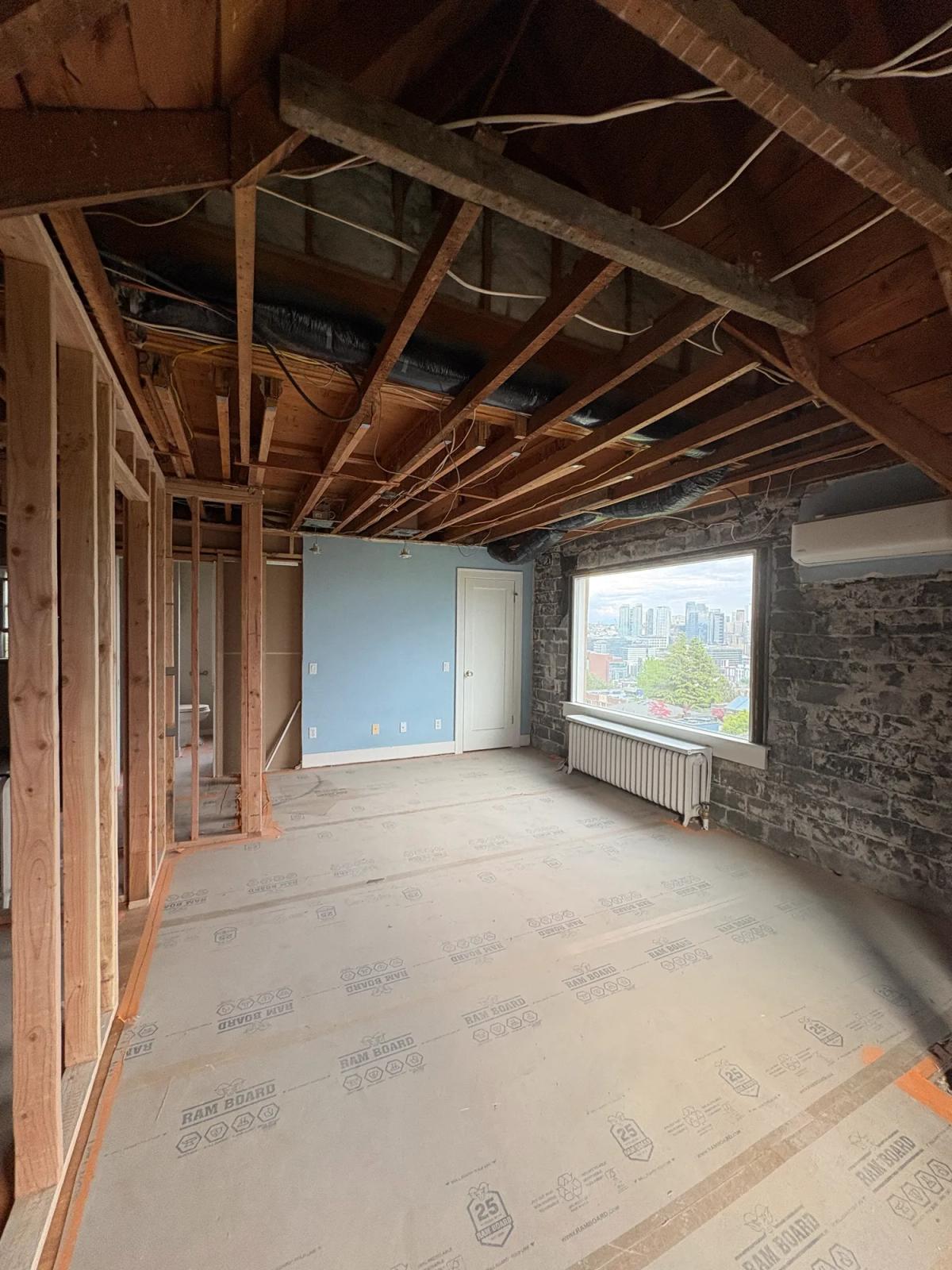 Room taken down to the studs and joists, floor protected with Ram Board
