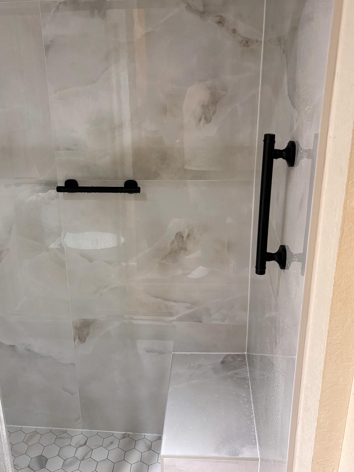 Built-in tiled bench, grab bar, and hexagon mosaic floor