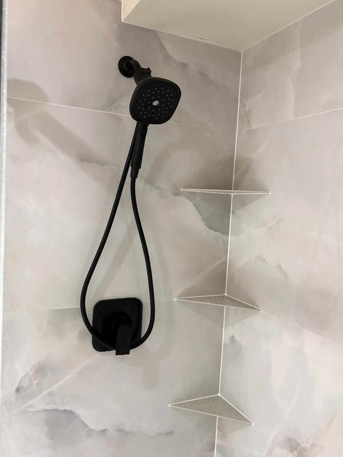 Matte-black shower fixtures and corner shelves